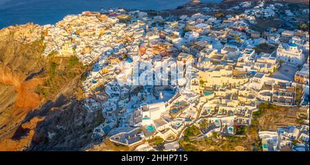 Malerische Luftdrohnenansicht des berühmten Dorfes Oia mit weißen Häusern während des Sonnenaufgangs auf Santorini, Griechenland, Europa. Luxusreisen. Sommerurlaub Stockfoto