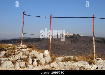 Monte Santo (Skalnica) vom Kamm der Sabotin aus gesehen. Monte Santo war das Theater blutiger Schlachten während des Ersten Weltkriegs. Die Kirche auf der Spitze wurde von der italienischen Artillerie, die auf dem Berg Sabotin aufgestellt wurde, zerstört. Es wurde in den Jahren zwischen 1924 und 1928 wieder aufgebaut. Stockfoto