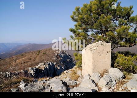 Der unzugängliche Kamm des Monte Sabotino (Sabotin) blickt über das enge Tal des Flusses Isonzo (Soca). Der gepflanzte weiße Pfosten markiert die Grenze zwischen Italien und Slowenien und erinnert uns daran, dass in den Jahren des Kalten Krieges der Eiserne Vorhang entlang dieser Linie verlief. Stockfoto