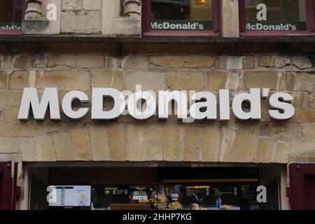 BRÜGGE, BELGIEN - 23. JANUAR 2022: McDonald's-Schild gegen eine Steinmauer in einer alten Stadt Stockfoto