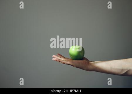 Grüne Äpfel auf der Hand. Minimalismus Stockfoto