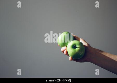 Grüne Äpfel auf der Hand. Minimalismus Stockfoto