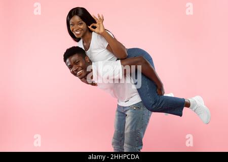 Glückliches schwarzes Paar, das okay gestikuliert und Spaß hat Stockfoto