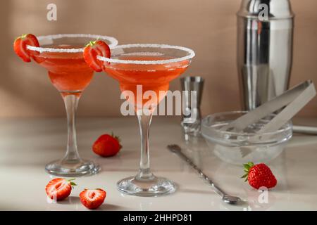 Frisch hausgemachte Erdbeer-margarita-Cocktails mit Bargeräten auf dem Tisch. Zubereitung von erfrischenden Cocktails im Sommer. Stockfoto