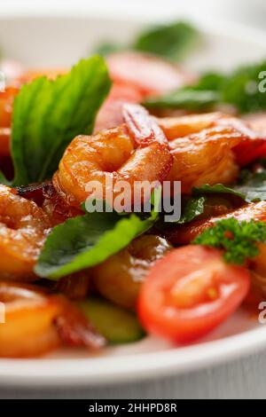 Nahaufnahme von frischen Garnelen, Tomaten, Rucola und grünem Salat, vertikales Bild. Stockfoto