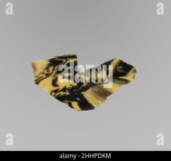 Glasmosaik-Inlay-Fragment Ende des 1st. Jahrhunderts v. Chr.–Anfang des 1st. Jahrhunderts n. Chr. Römisches Fragment von Revetment-Plakette.Transparentes tiefviolettes, schwarz erscheinendes und opakes Gelb.Flachinlay.Marmormosaik-Muster in purpurem Boden mit unregelmäßigen gelben Linien und Streifen.zweigebrochen und repariert; polierte Oberseite; Lochfraß von Oberflächenblasen, mit einigen Oberflächenrissen und Spänen; Abstumpfen, Lochfraß und schillernde Verwitterung auf der Unterseite; Verwitterung an gezackten Kanten, aber zwei Kanten beim Bruch unverwittert. Glasmosaik-Inlay-Fragment. Römisch. Spätes 1st Jahrhundert B.C.–frühes 1st Jahrhundert A.D.. Glas; Guss. Early Impe Stockfoto