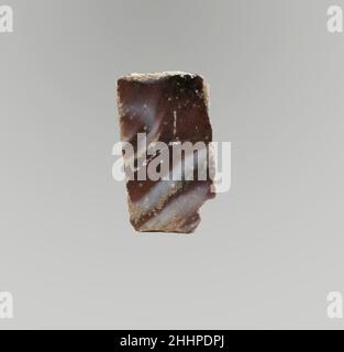 Glasmosaik-Inlay-Fragment Ende des 1st. Jahrhunderts v. Chr.–Anfang des 1st. Jahrhunderts n. Chr. römisch Durchscheinendes Lila und opakes Weiß.dünnes, flaches Parallelogramm.Marmormosaik-Muster aus Abschnitten eines einzelnen Rohres in violettem Boden mit unregelmäßigen weißen Fäden und Streifen.verwitterter Chip an einer Ecke; polierte Oberseite; Lochfraß und Verwitterung von Oberflächenblasen; Stumpfe, tiefe Lochfraß und schillernde Verwitterung an Unterseite und Kanten. Glasmosaik-Inlay-Fragment. Römisch. Spätes 1st Jahrhundert B.C.–frühes 1st Jahrhundert A.D.. Glas; Guss. Frühkaiserlich. Glas Stockfoto