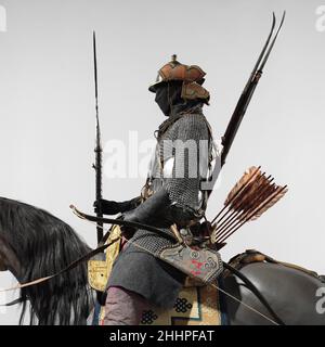 Armored Cavalryman 18th–19th Century Tibetisch, und möglicherweise Bhutan und Nepalese Diese Figur wurde basierend auf Fotografien zusammengestellt, die in den Jahren 1930s und 1940s in der tibetischen Hauptstadt Lhasa während des Großen Gebetfestes aufgenommen wurden. Die Fotos zeigten Truppen der zeremoniellen gepanzerten Kavallerie, die wahrscheinlich ab Mitte des 17. Oder 18. Jahrhunderts eine standardisierte Ausrüstung trugen, wie sie von der Zentralregierung Tibets vorgeschrieben wurde. Die Ausrüstung umfasste einen Helm, ein Posthemd, einen Satz von vier Spiegeln, einen gepanzerten Gürtel, einen Bogenkoffer und Köcher, eine Streichholzmuskulatur, einen Bandolee mit Schießpulver Stockfoto