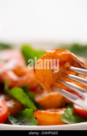 Nahaufnahme von frischen Garnelen, Tomaten, Rucola und grünem Salat, vertikales Bild mit Kopierfläche. Stockfoto