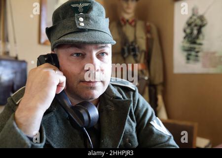 Porträt eines Mannes in Wehrmachtsuniform spricht am Telefon Stockfoto