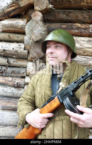 Porträt eines Mannes, der mit dem Maschinengewehr PPSh-41 posiert Stockfoto