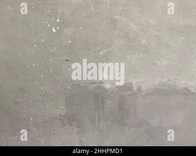 Eine graue Betonwand mit Farbflecken Stockfoto