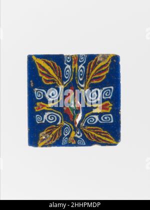 Glasmosaikeinlage 1st. Jahrhundert v. Chr.–1st. Jahrhundert n. Chr. ägyptischer, ptolemäischer oder römischer halbopaker kobaltblauer Boden; Dekoration in opaken weißen, gelben, roten und graugrünen Farben.quadratisch, dünn, Flache Plakette mit leicht abgeschrägten Rändern.symmetrisches Lotus- und Palmettenmotiv, angeordnet um eine zentrale, komprimierte, vierblättrige Rosette, mit einer großen Palmette an jeder Ecke, mit doppelten Spiralwuluten, die einen Rahmen zu einer kleinen, verzerrten Lotusblume auf jeder Seite bilden.gebrochen und repariert mit kleinen Löchern und Rissen; Oberseite geschliffen und poliert; verwittert Oberfläche Blasen, Verwitterung an den Kanten und zurück.Square, viele Co Stockfoto