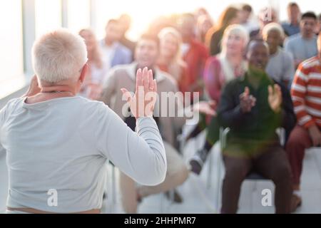 Erfolgreiche ältere Frau, die über etwas in einem Business-Training Stockfoto
