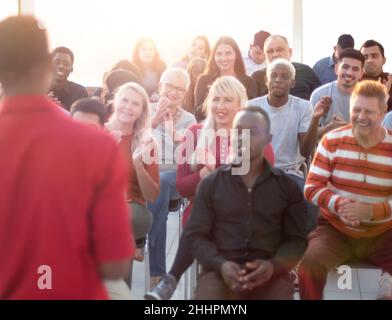 Junge Rednerin begrüßt das Publikum im Konferenzraum. Stockfoto