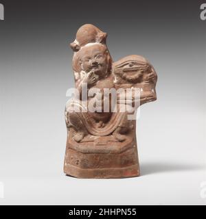 Terrakotta-Statue von Harpokrates ca. 2nd Jahrhundert A.D. Roman, ägyptisch mit Mondheaddress und Locke; kleiner dekorierter Schrein auf Knie; rechte Hand am Mund.. Terrakotta-Statue von Harpokrates 245512 Stockfoto