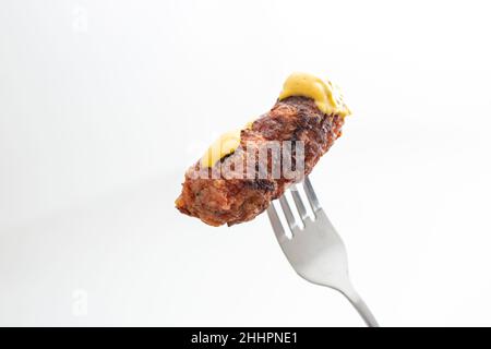 Traditionelles rumänisches gegrilltes Hackfleisch, Mici oder Mititei auf einer Metallgabel Stockfoto