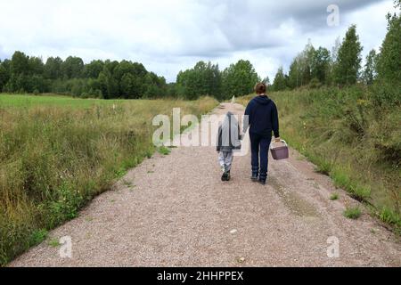 Mutter und Sohn gehen in den Wald für Pilze, Karelien Stockfoto