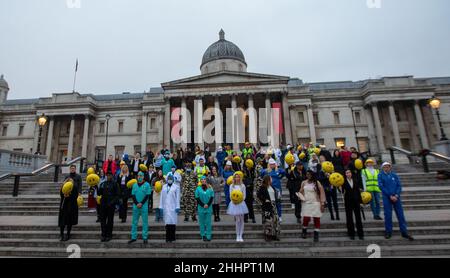 London, England, Großbritannien. 25th Januar 2022. 100 Arbeiter aus 11 verschiedenen Sektoren halten emoji-förmige Ballons, um die Ergebnisse von Indeed's „Work Happiness Score“, der weltweit größten Studie zum Arbeitsglück auf dem Trafalgar Square, zu veranschaulichen. (Bild: © Tayfun Salci/ZUMA Press Wire) Stockfoto