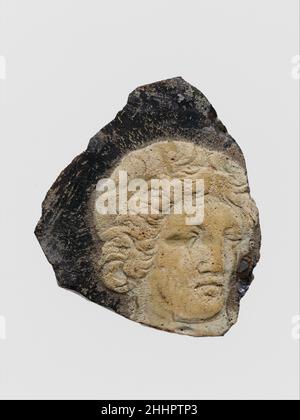 Glasplatten-Fragment aus Kameo-Plakette Ende 1st. Jh. v. Chr.–Anfang 1st. Jh. n. Chr. römisch Durchscheinend tiefviolett mit opaker weißer Überlagerung.flache Unterseite; Oberseite mit flacher Reliefverzierung.in Relief in Weiß, Kopf der Figur in Dreiviertelansicht nach rechts gedreht, mit welligem Haar.an allen Seiten gebrochen mit verwitterten Kanten; Dullend, leicht zerstückelt, verwitternde Flecken und brillantes Schillern.das Fragment stammt aus einer flachen Glasscheibe, wahrscheinlich eher aus einer Plaque als aus einem Gefäß.Dieses Fragment stammt aus einer flachen Glasscheibe, wahrscheinlich eher aus einer Plaque als aus einem Gefäß. Es ist mit einer Flosse dekoriert Stockfoto