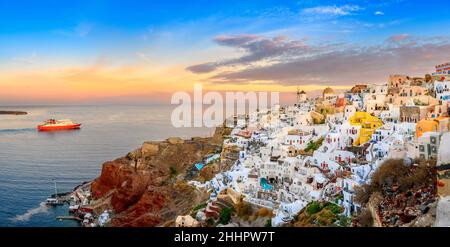 Fantastische Sonnenuntergangsansicht des traditionellen griechischen Dorfes Oia auf Santorini Insel, Griechenland, Europa. Luxusreise. Passagierfähre zur Insel. Summ Stockfoto