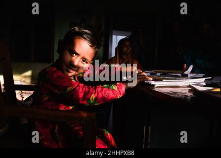 Die Schüler werden in eine ländliche Grundschule aufgenommen, und neue Schulbücher werden frei an die Schüler verteilt, die von der Regierung zur Verfügung gestellt werden. Nabin Nagar, Indien. Stockfoto