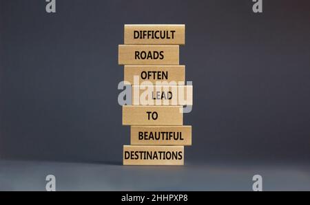 Motivationssymbol. Blöcke mit Worten schwierige Straßen führen oft zu schönen Zielen. Schöner grauer Tisch, grauer Hintergrund, Kopierraum. Bus Stockfoto