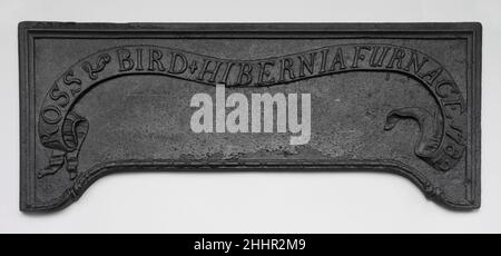 Ofenplatte 1782 von Hibernia gegossen Ofenfeuerungen und einzelne Platten aus Öfen sind fast alles, was überlebt, um uns an die großen Eisengießereien von New Jersey und Ost-Pennsylvania zu erinnern, die Teil der größten Industrie im kolonialen Amerika waren. Die Zierteller, obwohl die niedersten Metalle, wurden aus Mahagoni-Mustern gegossen, die Handarbeit der besten Möbelschnitzer. Frühe Beispiele wurden mit biblischen Zitaten und statischen Arrangements von Herzen und Tulpen geschmückt, die deutschen Präzedenzfällen folgten (47.137.10). Nach 1770 hergestellte Teller mit dem verspielten naturalistischen Motiv Stockfoto