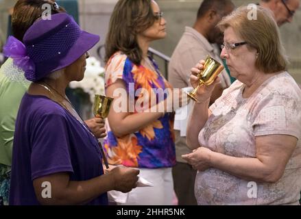 Die Gläubigen feiern die Kommunion während der Messe Mob III in der Sts. Teresa und Bridget Catholic Parish in St. Louis. Stockfoto