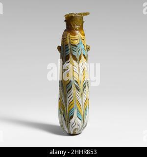 Glas-Alabastron (Parfümflasche) Ende 4th–Anfang 3rd Jahrhundert v. Chr. Griechisch, östliches Mittelmeer Durchscheinend hellgrünlich-gelb, mit Griffen in gleicher Farbe; Trails in opak-gelb, opak-türkis-blau und opak-weiß.Horizontale Randscheibe, als Spiralspule um den Hals gemacht; zylindrischer, schräg geneigter Hals; kleine Schulter; gerader zylindrischer Körper, Mit nach oben geknöpfter Form; konvexer Boden; am Körper zwei kleine Ringgriffe, über dem Trailmuster angebracht.Ein feiner gelber Trail, der am Rand der Randscheibe befestigt ist; am Körper abwechselnd gelbe, türkisblaue und weiße Bänder, die von der Oberseite des bo gewickelt sind Stockfoto