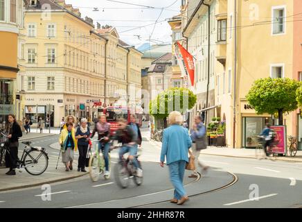 Innsbruck, Österreich - April 17th 2018: Fußgänger und Radfahrer passieren die historischen Gebäude am Marktgraben Stockfoto