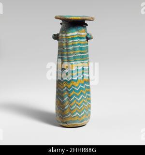 Glas-Alabastrone (Parfümflasche) Ende 4th–Anfang 3rd Jh. v. Chr. Griechisch, östliches Mittelmeer blickdicht, helltürkisgrün, mit Griffen in gleicher Farbe; Spuren in opak-weiß und opak-gelb.breite, flache Randscheibe, einseitig schräg geneigt; kurzer zylindrischer Hals; fast unmerkliche schräge Schulter; gerader zylindrischer Körper, nach oben zugeneigt; unebener eingedrückter Boden; Oben auf dem Körper, zwei Ösen Griffe, über Trail-Muster angebracht, beide mit aufgewickelten nach oben Einrückungen.Eine gelbe Spur am Rand der Rand-Scheibe befestigt; eine weitere gelbe Spur und eine weiße Spur, nach der gelben, Wunde spiralförmig aus Stockfoto