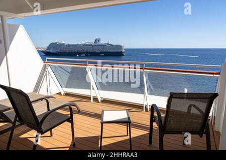 Blick vom großen Balkon nach hinten auf Norwegian Bliss mit Blick auf ein anderes Schiff, das vor Anker liegt Stockfoto