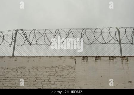 Stacheldraht an einer Betonwand Stockfoto