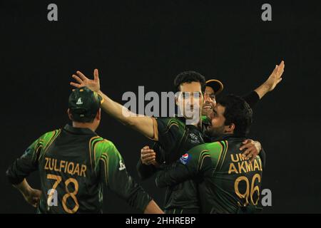 Der pakistanische Cricket-Spieler Umar Gul (M) feierte mit seinem Teamkollegen Umar Akmal im Spiel 16th, Group 2 ICC (International Cricket Council) Cricket World Cup T20 2014, zwischen Australien und Pakistan im Sher-e-Bangla National Stadium, Mirpur.Pakistan gewann mit 16 Läufen. Stockfoto