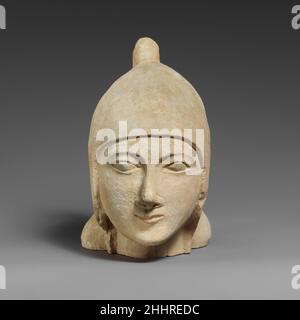 Kalksteinkopf eines bärtlosen Mannes, der einen konischen Helm trägt, in der ersten Hälfte des 6th. Jahrhunderts v. Chr. Zyperns die Wangenstücke des Helms bedecken die Ohren; der Gipfel kurvt zurück und das Ende ist gebrochen. Das Gesicht zeigt feine Gesichtszüge, ein schwaches Lächeln und steifen Mund, eine leicht angehobene, spitze Nase, kleine längliche Augäpfel und tief angesetzt, Geschlüpfte Augenbrauen. Die Stirn ist meist mit dem Helm bedeckt. Kalksteinkopf eines bärtlosen Mannes mit einem konischen Helm 242094 Stockfoto