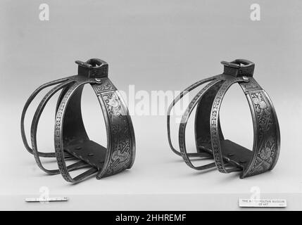 Ein Paar Stirrups aus einer Pferderüstung für ein Mitglied der Familie Collalto ca. 1560 Italienisch, wahrscheinlich Mailand Diese Steigbügel gehören zu einer Pferdepanzerung (gem 21.139.2), aus der Zeit um 1560, das ist eines der wenigen vollständigen Beispiele seiner Zeit zu erhalten. Sie stammt aus der Waffenkammer der Grafen Collalto auf der Burg von San Salvatore, in der Nähe von Treviso, wo sie vermutlich vom späten 16. Bis zum frühen 20. Jahrhundert aufbewahrt wurde. Zu den Bändern mit geätzten Ornamenten gehören klassisch inspirierte Trophäen aus Waffen und Rüstungen sowie Musikinstrumente. Diese waren Standard-Dekorative Motive auf Stockfoto