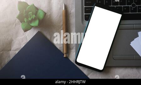 Handymockup-Vorlage mit weißem Bildschirm auf einem Laptop für Telearbeit und Home Office-Konzept, Stockfoto