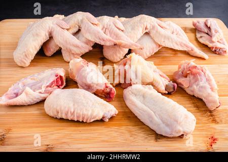 Rohe Chicken Wings in Wingettes und Drumettes schneiden: Ganze ungekochte Chicken Wings in Stücke schneiden Stockfoto