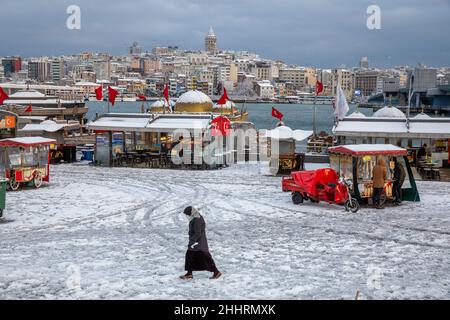 Menschen, die am 25. Januar 2022 im Stadtteil Eminonu in Istanbul, Türkei, im Schnee spazieren gehen. Stockfoto