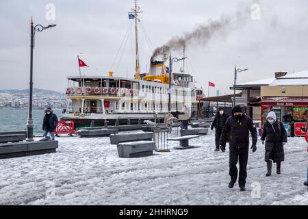 Menschen, die am 25. Januar 2022 im Stadtteil Eminonu in Istanbul, Türkei, im Schnee spazieren gehen. Stockfoto