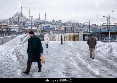 Menschen, die am 25. Januar 2022 im Stadtteil Eminonu in Istanbul, Türkei, im Schnee spazieren gehen. Stockfoto