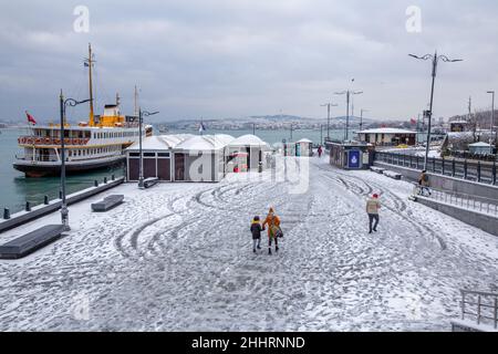 Menschen, die am 25. Januar 2022 im Stadtteil Eminonu in Istanbul, Türkei, im Schnee spazieren gehen. Stockfoto