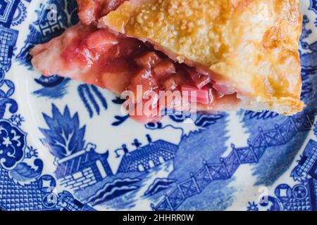 Erdbeer-Rhabarber-Kuchenscheibe auf blauem japanischem Teller Stockfoto