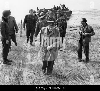 Der britische Premierminister Winston Churchill und der Feldmarschall Bernard Montgomery überqueren den Rhein. Am 25th. März überquerte Churchill mit Field Marshall Montgomery in einem amerikanischen L.C.U.P. das Ostufer des Rheins Das Bild zeigt: Der Premierminister und die Partei, die nach dem Anlaufen die Bank hochlaufen. 26th. März 1945. Stockfoto