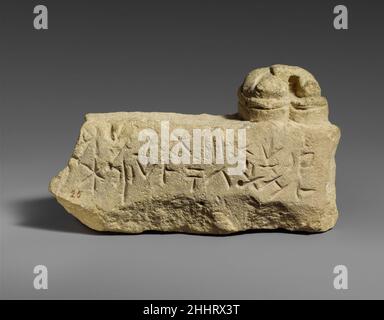 Kalksteinsockel mit den Füßen einer weiblichen Statuette (?) Ende des 4th.–2nd. Jahrhunderts v. Chr., zypriotisch? Zwei geformte Zehen stehen auf dem rechten linken Rand eines fragmentarischen Sockels mit einer zypro-silbischen Inschrift. Kalksteinsockel mit den Füßen einer weiblichen Statuette (?) 241857 Stockfoto