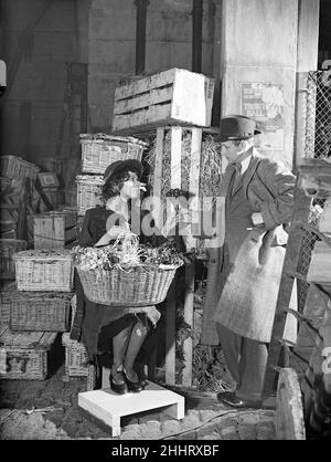 Dreharbeiten zu Pygmalion, Regie: Anthony Asquith und Leslie Howard, in den Pinewood Studios, London, England, 20th. März 1938. Schauspieler, Leslie Howard & Wendy Hiller als Blumenmädchen. Stockfoto