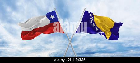 Gekreuzte Nationalflaggen von Chile und Bosnien und Herzegowina, die bei bewölktem Himmel im Wind winken. Symbolisiert Beziehung, Dialog, Reisen zwischen zwei Stockfoto