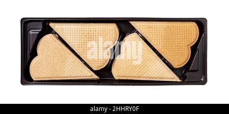 Süße herzförmige Waffeln zur Eiscreme-Dekoration in einem schwarzen Kunststoffbehälter-Ausschnitt. Dünne flache Waffelplätzchen zum Garnieren. Gebackenes Gebäck. Stockfoto