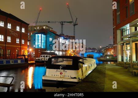 Verankerte Boote auf dem Kanal bei Granary Wharf im Stadtzentrum von Leeds. 3 Turmdrehkrane sind bei der Entwicklung von Tower Works zu sehen. Stockfoto